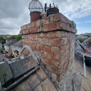 Damaged chimney render and deteriorated lead flashing on roof in holyhead
